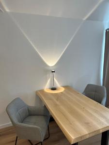 una mesa de madera con 2 sillas y una lámpara en Messewohnung für 2, en Giesen