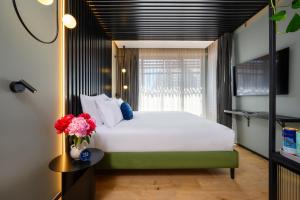 Un dormitorio con una gran cama blanca y una ventana en Hotel Poli Urban, en Tel Aviv
