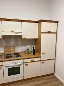 een keuken met witte kasten en een fornuis bij Messewohnung für 2 in Giesen