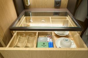 a drawer in a cabinet with a sink and dishes at Mayfield Hotel Seoul in Seoul