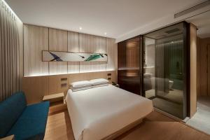 a bedroom with a white bed and a glass shower at Mayfield Hotel Seoul in Seoul