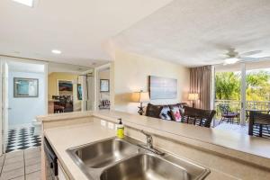 a kitchen with a sink and a living room at The Exuma Cay by Brightwild-Pool View & Parking in Key West