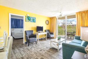 uma sala de estar com um sofá, uma cama e uma televisão em The Tortuga by Brightwild-Pool, Parking & Pets! em Key West