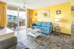 a living room with a blue couch and a table at The Tortuga by Brightwild-Pool, Parking & Pets! in Key West