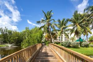 基韋斯特的住宿－The Samana Cay by Brightwild-Private Balcony，一座棕榈树和建筑的河流上的桥梁