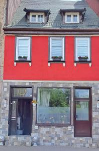 a red house with windows on a street at Peter´s Ferienwohnung in Schmalkalden
