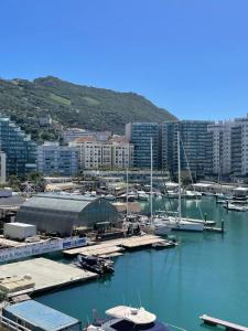 een groep boten aangemeerd in een haven met gebouwen bij Marina Club Luxury private studio with Pool and incredible views in Gibraltar