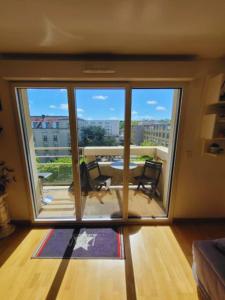 um quarto com uma grande janela e uma mesa e cadeiras em L'agréable Nid de Verdun. em Limeil-Brévannes