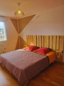 um quarto com uma cama grande e almofadas vermelhas em L'agréable Nid de Verdun. em Limeil-Brévannes
