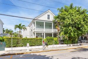 a white house with palm trees in front of it at Creme Brulee Suite by Brightwild in Key West