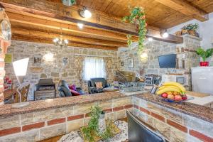 una cucina e un soggiorno con un muro in pietra di Casa Lukas Dračevac a Dračevac