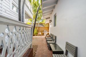 a group of benches sitting on a brick walkway at Creme Brulee Suite by Brightwild in Key West