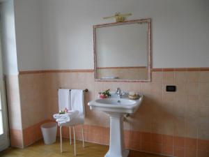 bagno con lavandino, specchio e asciugamani di Beb Villa Aurora a Carmagnola