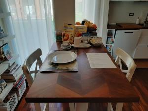 a wooden table with a plate of food on it at Room-Apartment 300 meters from the RACETRACK in Imola