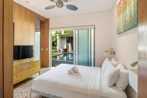 a bedroom with a white bed and a television at Contra House by Brightwild-Luxury Home With Pool in Key West