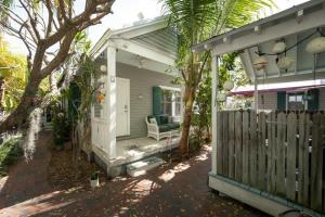 a porch of a house with a chair and a fence at The Conch by Brightwild-Pool & Quiet Area in Key West