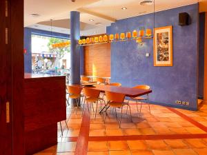 a dining room with a wooden table and chairs at Hotel Vila de Tossa in Tossa de Mar