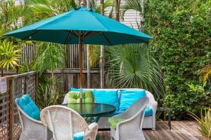 a patio table and chairs with a blue umbrella at Sunnyside Up in Key West