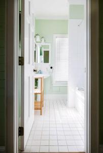 a bathroom with a sink and a white tiled floor at King Suite Balcony by Brightwild- at James House in Key West