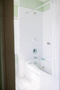 a white bathroom with a tub and a shower at King Suite Balcony by Brightwild- at James House in Key West
