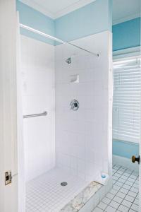 a bathroom with a shower with white tile at Deluxe King with Balcony by Brightwild- at James House with Parking! in Key West