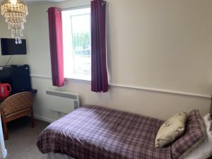 a bedroom with a bed and a window at The Jolly Drayman Pub and Hotel in Gravesend