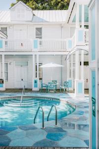 a swimming pool in front of a white house at Deluxe King with Balcony by Brightwild- at James House with Parking! in Key West
