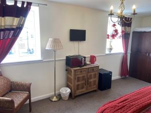 um quarto com uma cama, um sofá e uma televisão em The Jolly Drayman Pub and Hotel em Gravesend