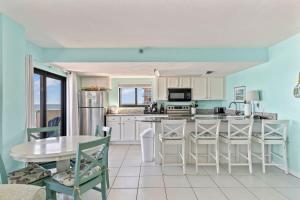 a kitchen with blue walls and a table and chairs at Ocean Front Penthouse with Incredible Views! Sunglow Resort 1003 by Brightwild in Daytona Beach Shores