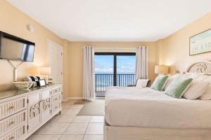 a bedroom with a large bed and a television at Oceanfront Condo with Amazing Views! Sunglow Resort 902 by Brightwild in Daytona Beach Shores