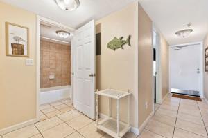 a hallway with a bathroom with a fish on the wall at Oceanfront Condo with Amazing Views! Sunglow Resort 902 by Brightwild in Daytona Beach Shores +26 photos