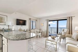 a living room with a table and a couch at Coastal Chic Suite at Sunglow Resort by Brightwild in Daytona Beach Shores