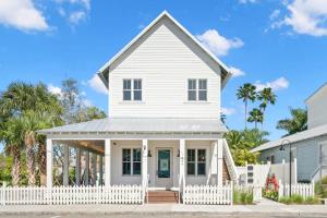a white house with a white picket fence at Casa Romeo - Luxury Ybor Apt, Steps to 7th Ave in Tampa