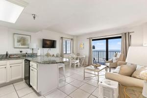 a kitchen and living room with a couch and a table at Coastal Chic Suite at Sunglow Resort by Brightwild in Daytona Beach Shores