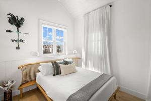 a white bedroom with a bed and a window at Casa Romeo - Luxury Ybor Apt, Steps to 7th Ave in Tampa