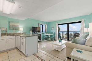 Aquamarine Suite at Sunglow Resort by Brightwild في Daytona Beach Shores: مطبخ وغرفة معيشة مع أريكة وطاولة