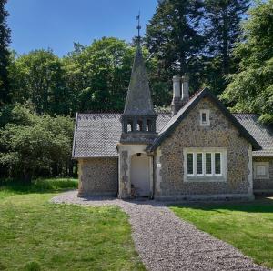 a stone house with a tower on top of a yard at Knuthenborg Safaripark in Maribo