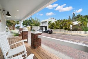 - une terrasse couverte avec un banc blanc et une vue sur la rue dans l'établissement Casa Padrón - Gorgeous Home, Steps to 7th Ave, à Tampa