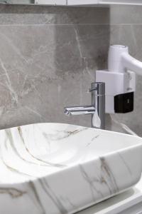 a white bathroom sink with a faucet on a counter at Te Aldo Hotel in Durrës