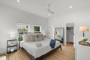 - une chambre blanche avec un grand lit et un miroir dans l'établissement Casa Padrón - Gorgeous Home, Steps to 7th Ave, à Tampa