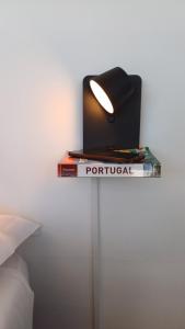una mesa con libros y una lámpara encima. en HI Coimbra - Pousada de Juventude, en Coímbra