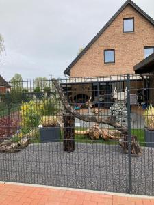einen Zaun vor einem Haus mit Tieren darin in der Unterkunft Ferienhaus Smidt in Emden