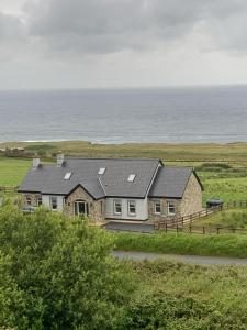 une maison sur le flanc d'une colline avec l'océan dans l'établissement Ocean View, à Ballycastle