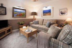 a living room with a couch and a tv at Eildon View in Melrose