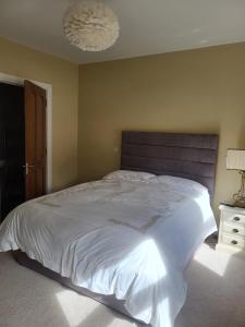 - une chambre avec un grand lit blanc et une lampe dans l'établissement Ocean View, à Ballycastle