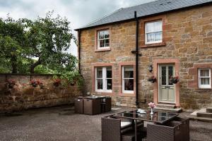 a brick house with a glass table in front of it at Eildon View in Melrose