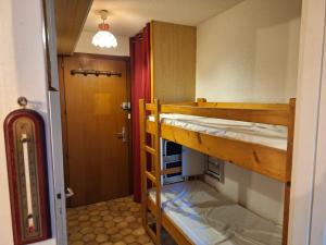 Zimmer mit 2 Etagenbetten und einer Tür in der Unterkunft Studio à la montagne - Portes du Soleil in Abondance