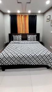 a bedroom with a large bed with black curtains at Bahria Town Lahore - NEXT INN Condo available at Best Price 402 in Lahore
