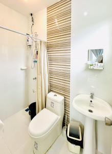uma casa de banho com um WC e um lavatório em Feel at Home Gensan Wi-fi Netflix Carport Hot Shower BBQ Grill em General Santos