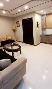 a living room with a couch and a table at Bahria Town Lahore - NEXT INN Condo available at Best Price 402 in Lahore +13 photos